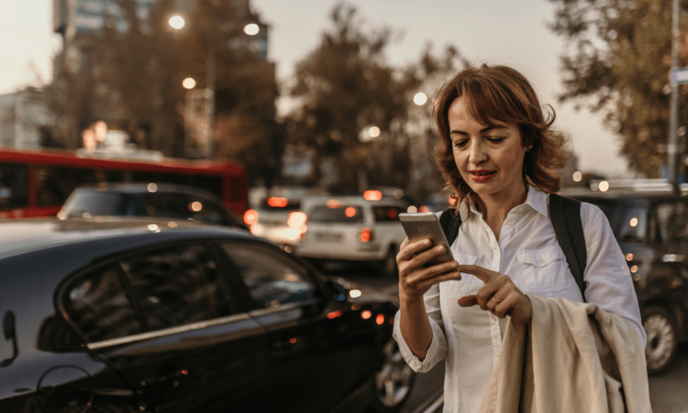 Important things to know London: This is an image of a lady trying to book an uber from her phone.