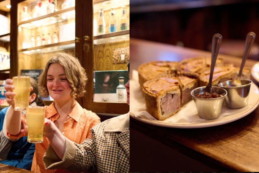 Woman raising a pint of cider in a London pub next to a plate of sliced pork pies with condiments