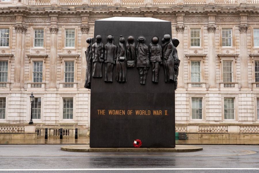 he Monument to the Women of World War II on Whitehall in London with a red poppy wreath laid at its base