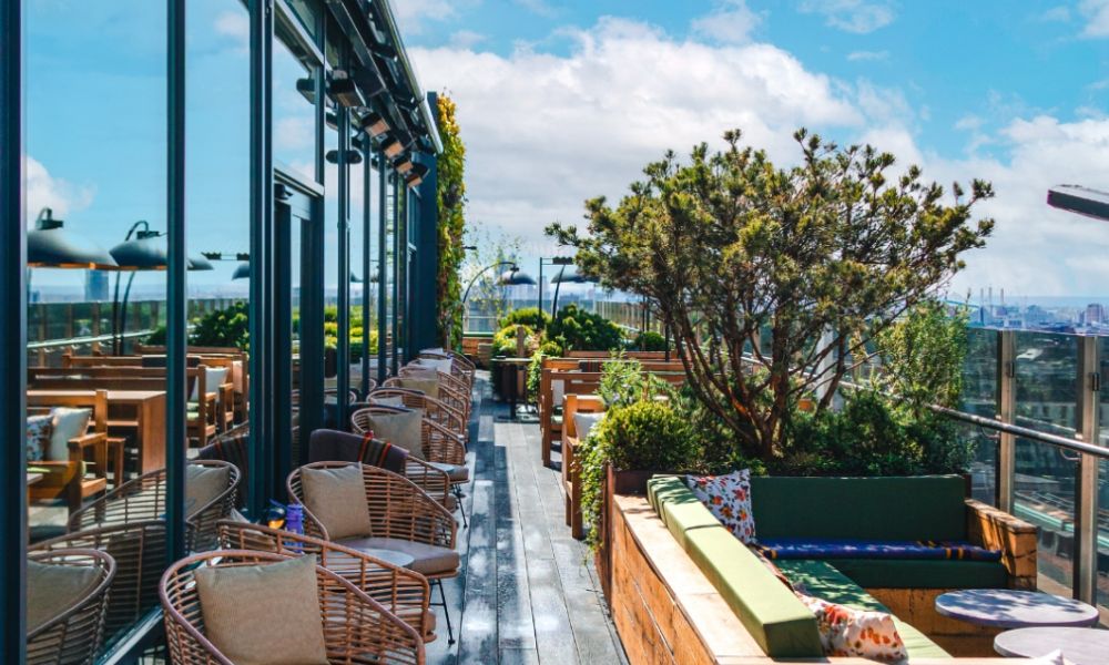 This is an image of a big deck lined with comfy couches and tables.