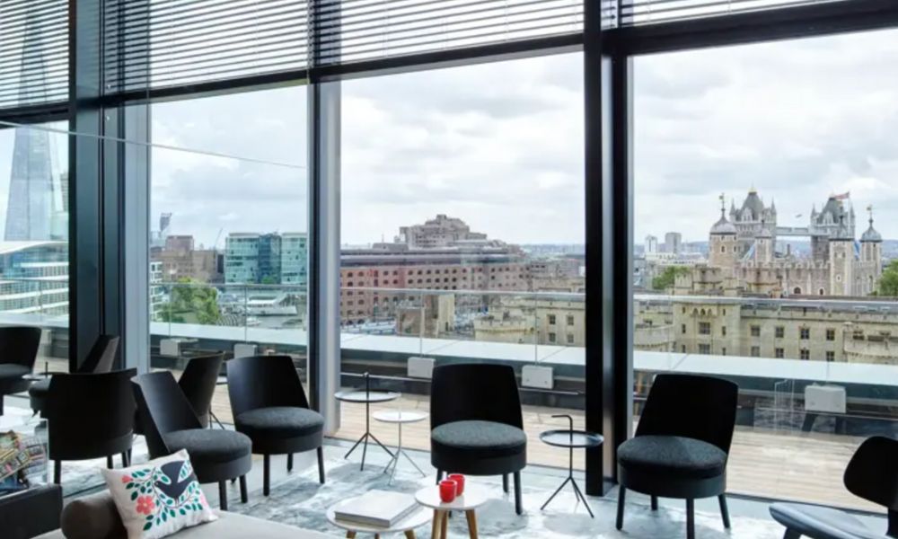 This is an image of a rooftop bar with an indoor / outdoor area and a view of The Tower of London.