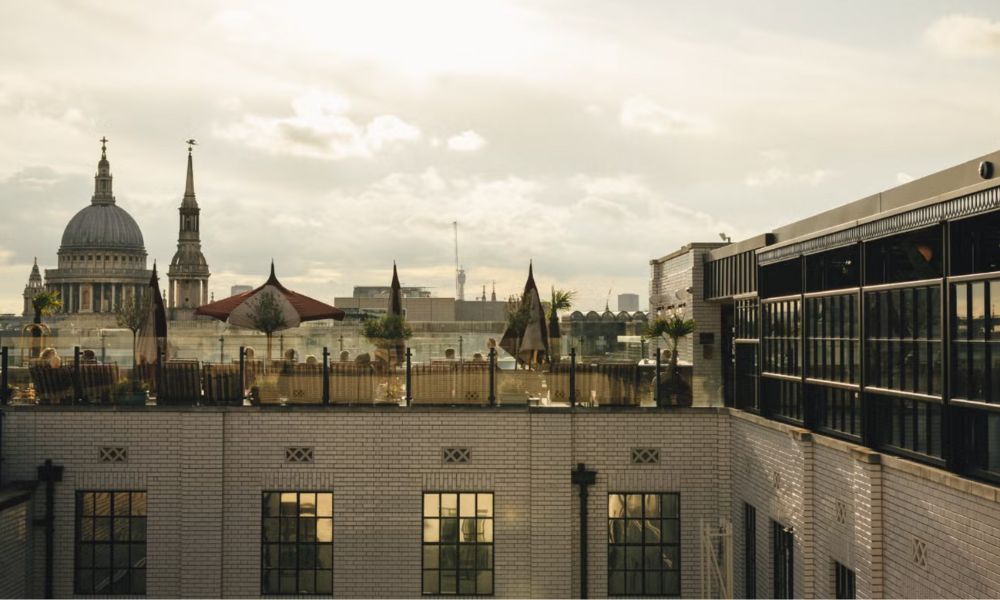 This is an image of a London rooftop bar with a pool and umbrellas to shade the sun. You can see St Paul's and other iconic sites from it.