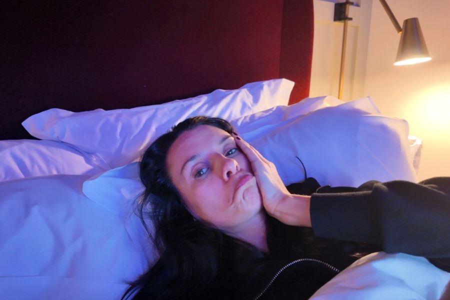 This is an image of Jess laying in bed with a sad expression on her face.