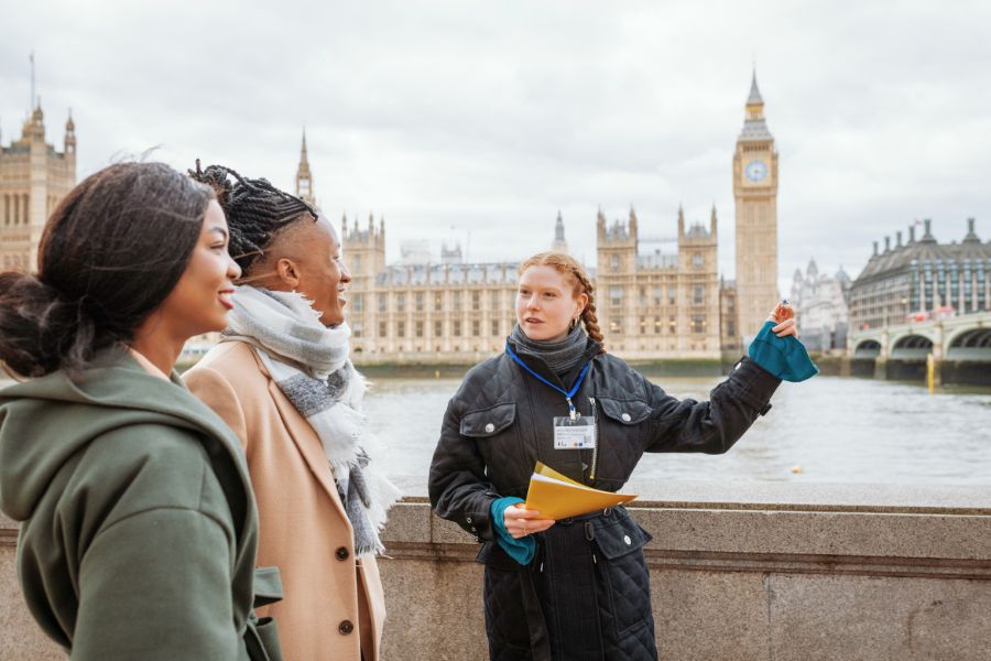 A tour guide showing visitors the House of Parliament from a generic spot in London