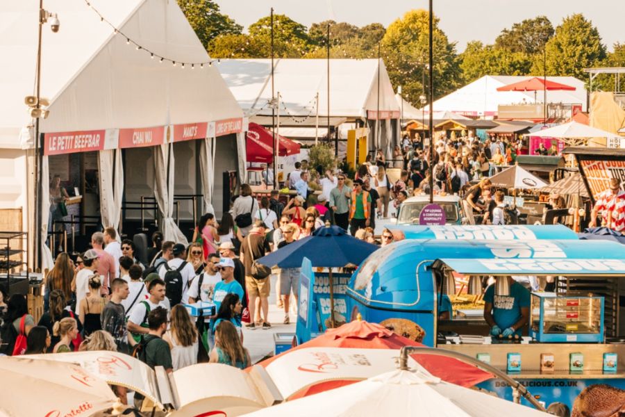 A busy outdoor food festival in Regent's Park on a sunny day, with crowds browsing food stalls, trucks and restaurant tents including a sign for Le Petit Beefbar