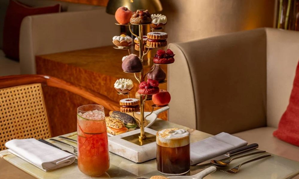 Unique afternoon teas in London: This is an image of a tiered stand with delicious drinks and artsy cakes.