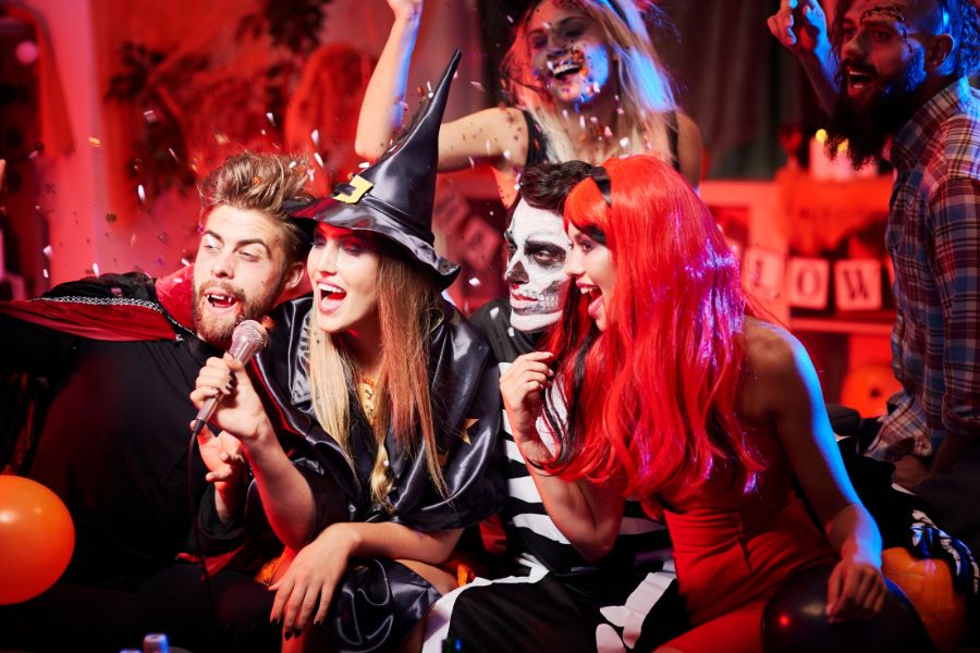 This is an image of a Halloween party where a group is dressed up in witch, dracula and dark Disney costumes.