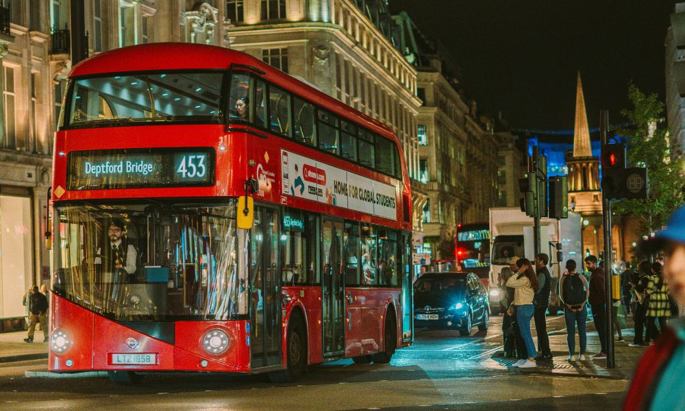 This is an image of a double decker bus driving down a prominent street in London.