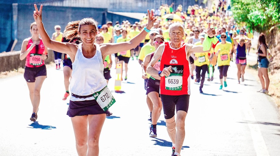 This is an image of people running in a marathon. The people at the front look super happy and energetic and there are hundreds of people following behind. 
