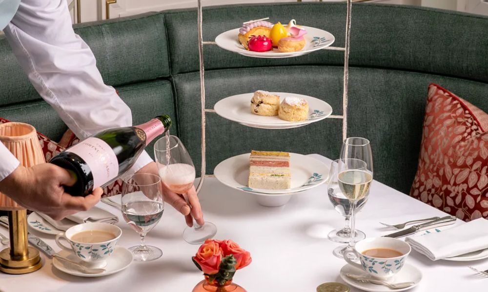 This is an image of a three-tired cake stand with a man pouring champagne.