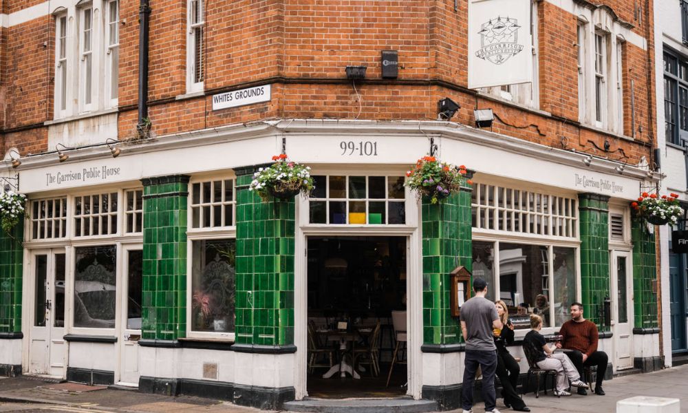This is an image of a pub with a brick exterior and green tiling on the outside.