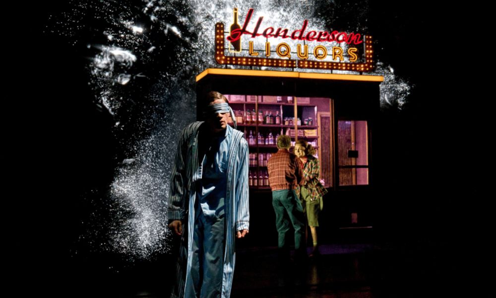 This image of a man in the dark wearing pyjamas and blindfolded in front of a liquor store.