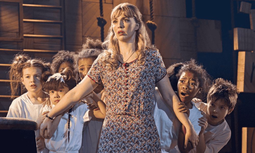 This is an image of Miss Honey holding all the kids back behind her in a classroom.