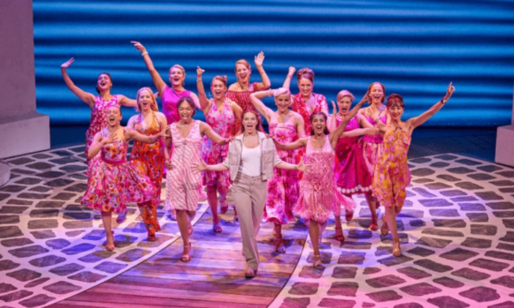 Best West End shows in London: This is an image of girls dancing in a group together with pink flowy dresses.