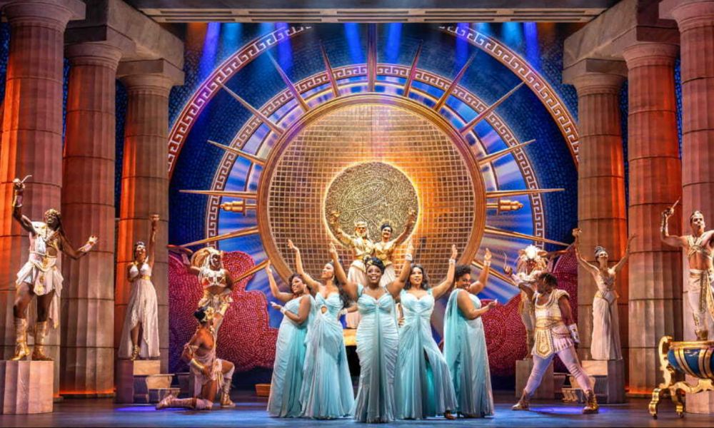 Best West End shows in London: This is an image of people on stage in incredible flowy, blue dresses dancing on stage.