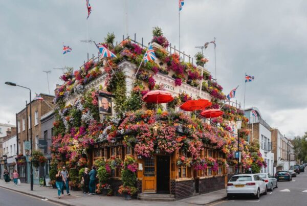 This is an image of the Churchill Arms in all its glory with florals and greenery covering the building.