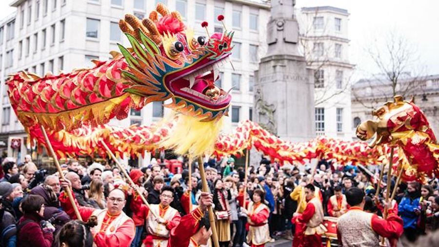 This is an image of the Lunar New Year Parade in London with people celebrating in the streets