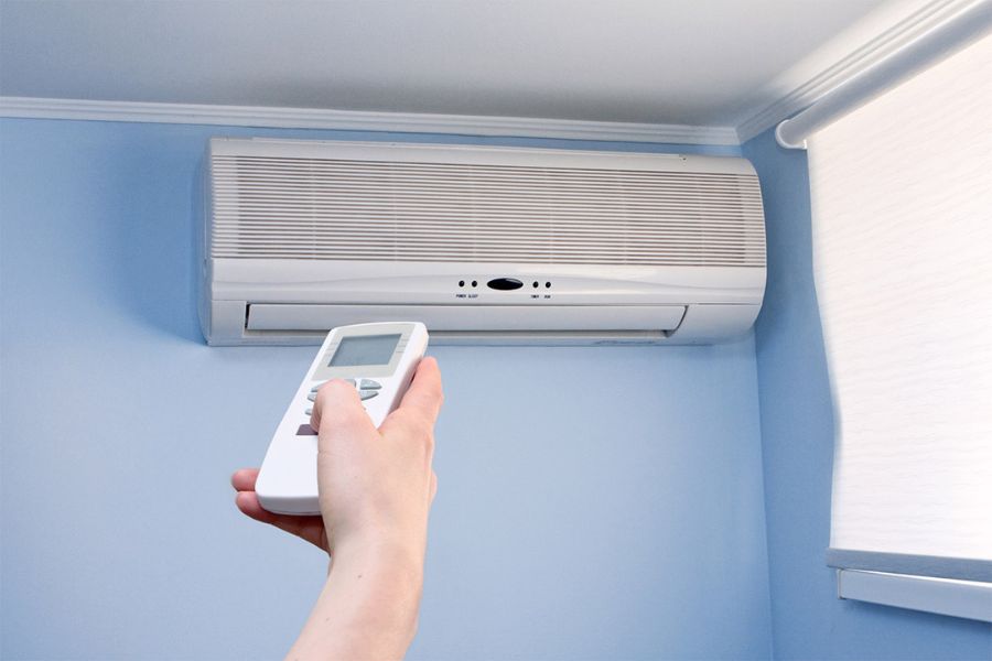 A person switching on the air conditioning which is usually unavailable in UK hotels. This is one of the important things to know when booking a London hotel, especially in the summers