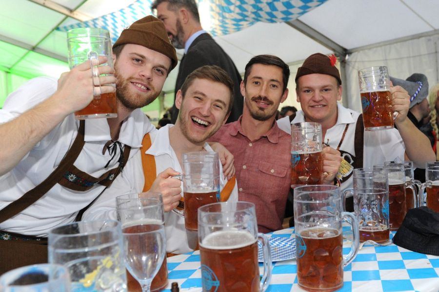 People having fun dressed up in traditional German attire during Oktoberfest in London.