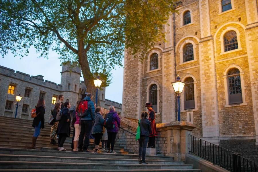 A guide leading a group of people for the tour of Tower of London at dusk. Also witness the Ceremony of the Keys in this guided tour of London attractions