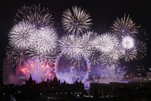 This is an image of big purple fireworks lighting up the London sky behind the London Eye.