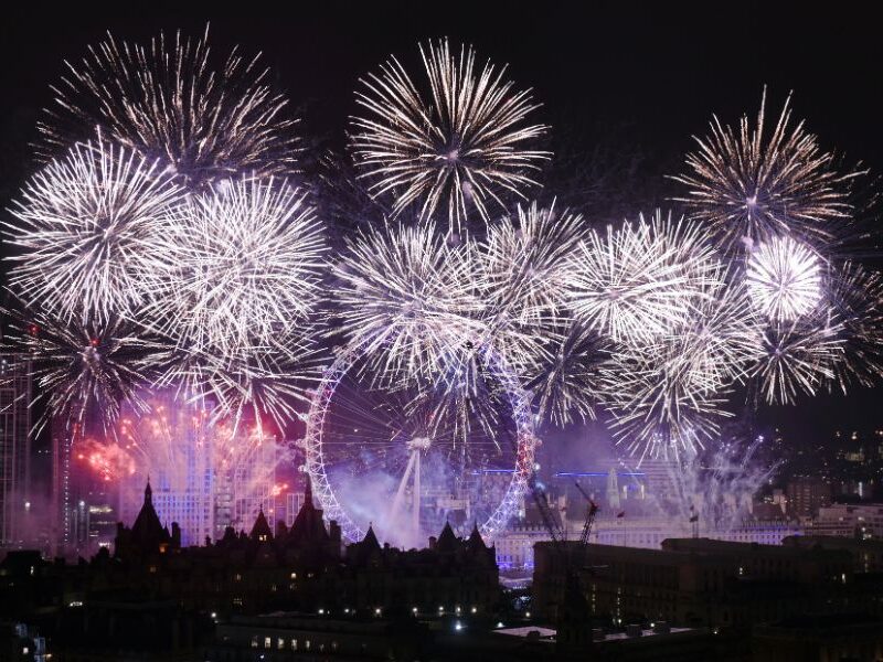 This is an image of big purple fireworks lighting up the London sky behind the London Eye.