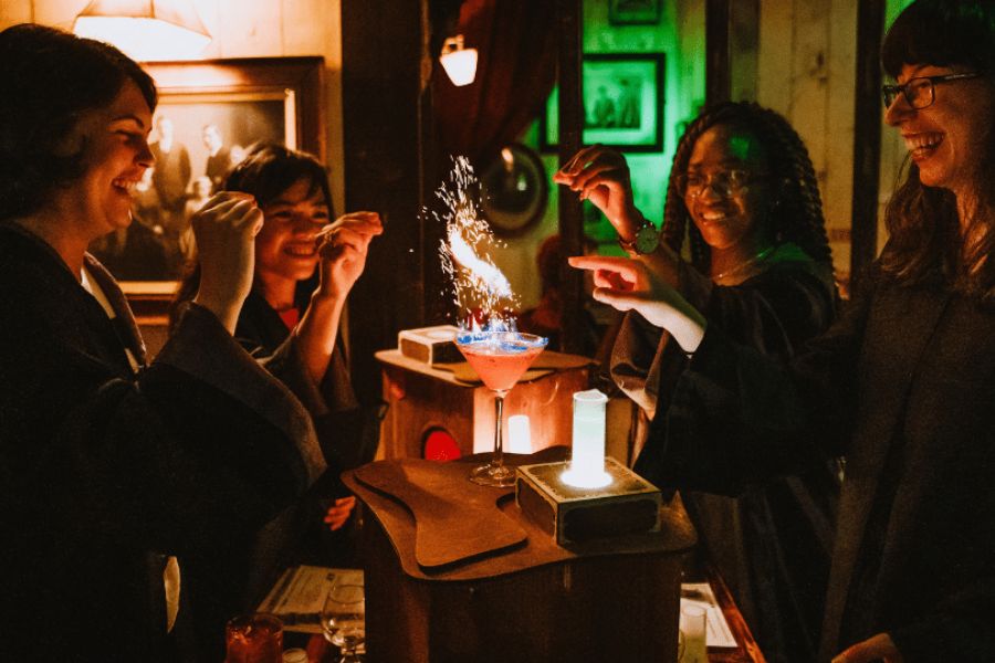 Freinds enjoying a boozy potion making session in their wizard's robes.