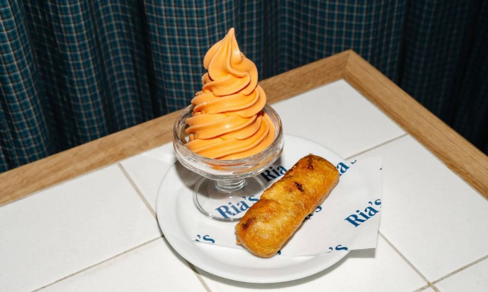 This is an image of a soft service ice cream and a battered dessert on a tiled table.