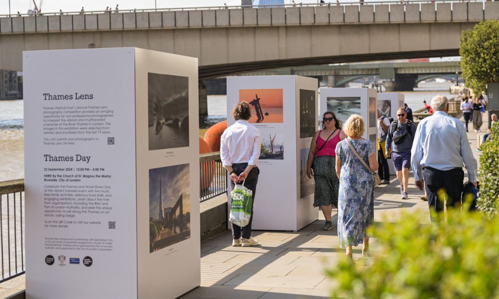 This is an image of an installation on the Thames whereby people are looking blocks that are full of artwork and history.