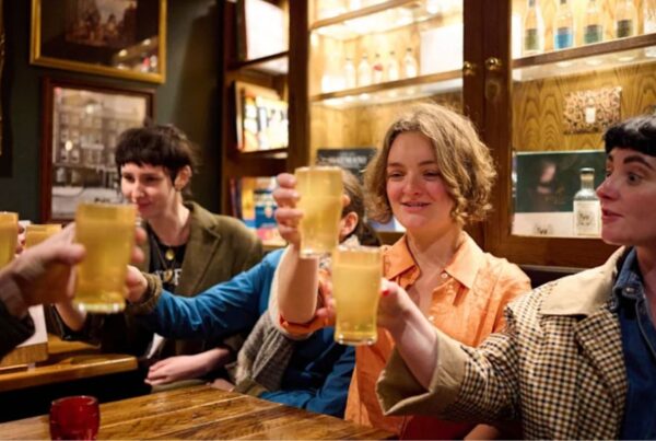 This is an image of a tour group holding up their beers to clink glasses.