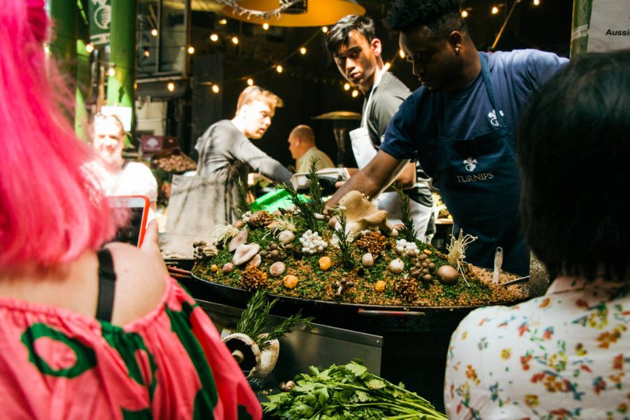 Vendors serving delicious food to customers at Borough Market. Exploring and eating your way through this known market is one of the best things to do in london in the winter