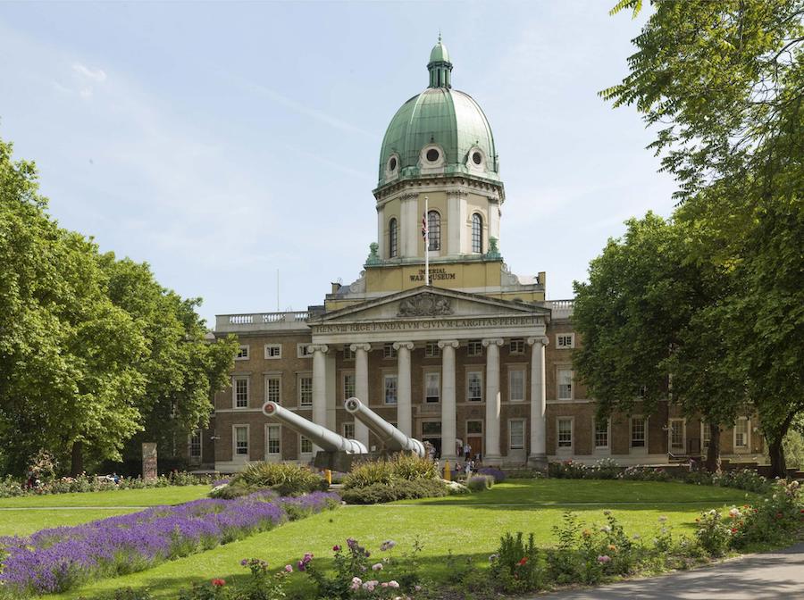 Entrance to the Imperial War Museum with two cannons in front and lavender plants lining the walkway