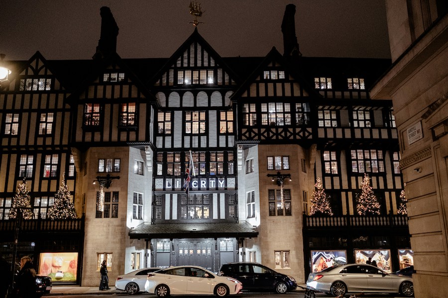 This is an image of the front profile of Liberty London – a department store in Central. There are cars in front of it and it is dark. Harrods is one of London's most overrated attractions, try Liberty London instead.