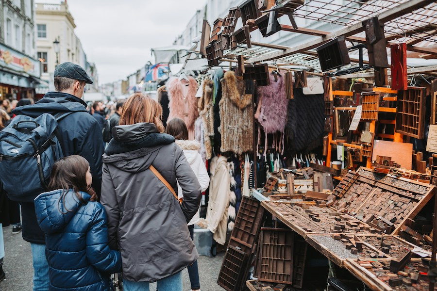 This is a picture of a family browsing a vintage market in London. There seems to be a lot of clothes and jewellery available.
