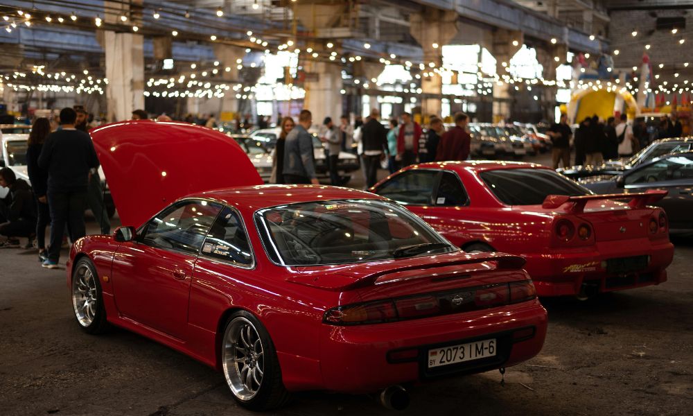 This is an image of classic cars lined up in a row with their hoods up as part of a car show.