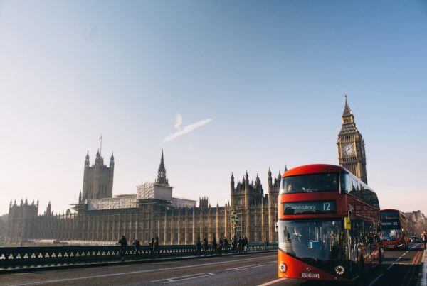 This image is of a double-decker bus driving over a bridge. You can see Big Ben and the Parliament houses behind it in the distance.