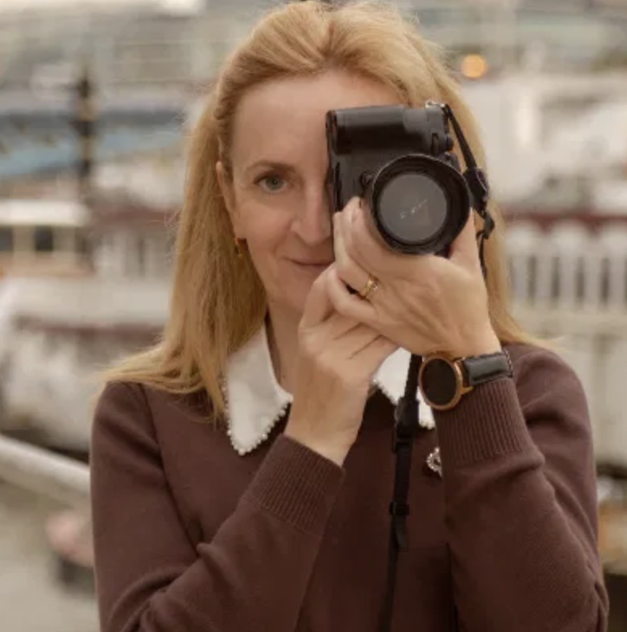 This is an image of Photographer Ewa holding a camera up to her eye to get the perfect shot.