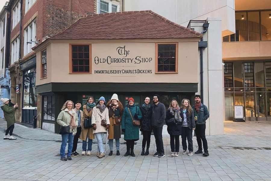 This is an image of a tour group standing in front of The Old Curiosity Shop in London.
