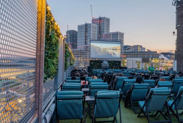 This is an image of an outfoor rooftop cinema. You can see London City's skyline in the background.