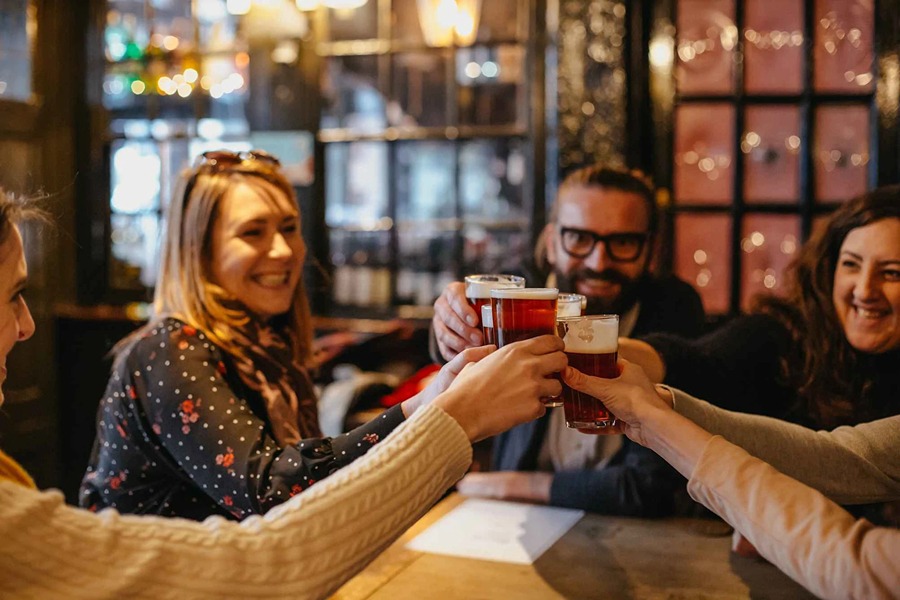 This is an image of a tour group holding up their beers to clink glasses.
