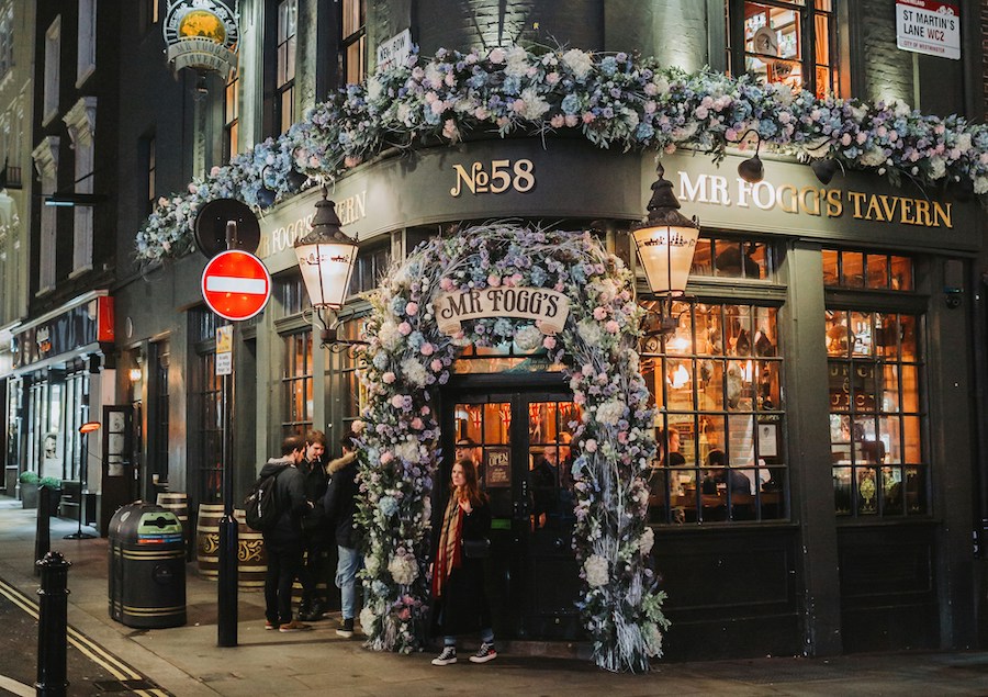This is an image of a pub in London with flower detailing around the entrance.