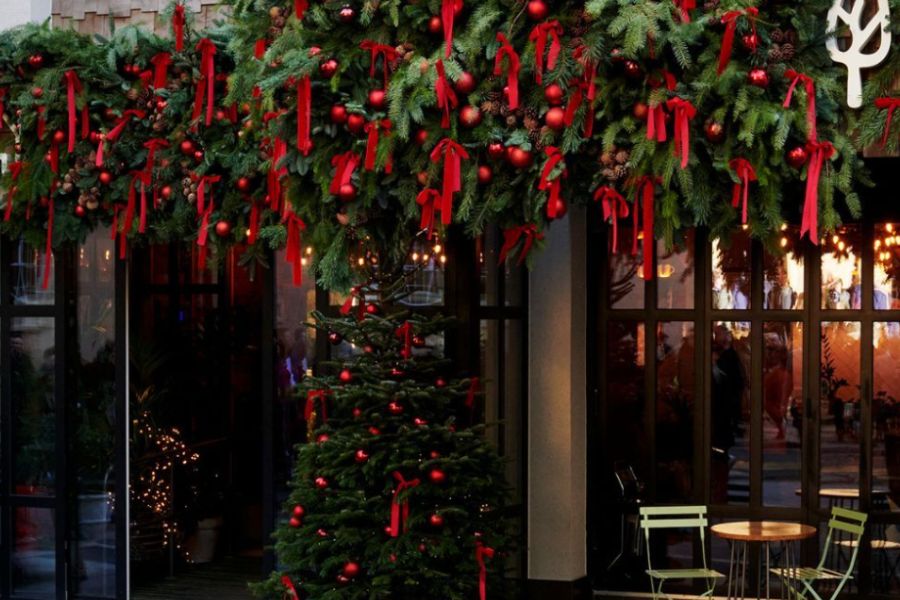 This is an image of a hotel with holly wreath and a Christmas tree out front.