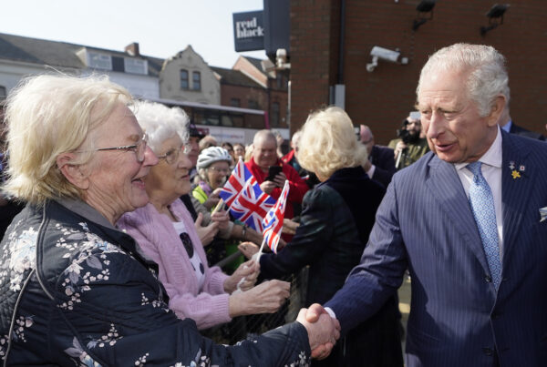 King Charles shaking hands with two elderly ladies.